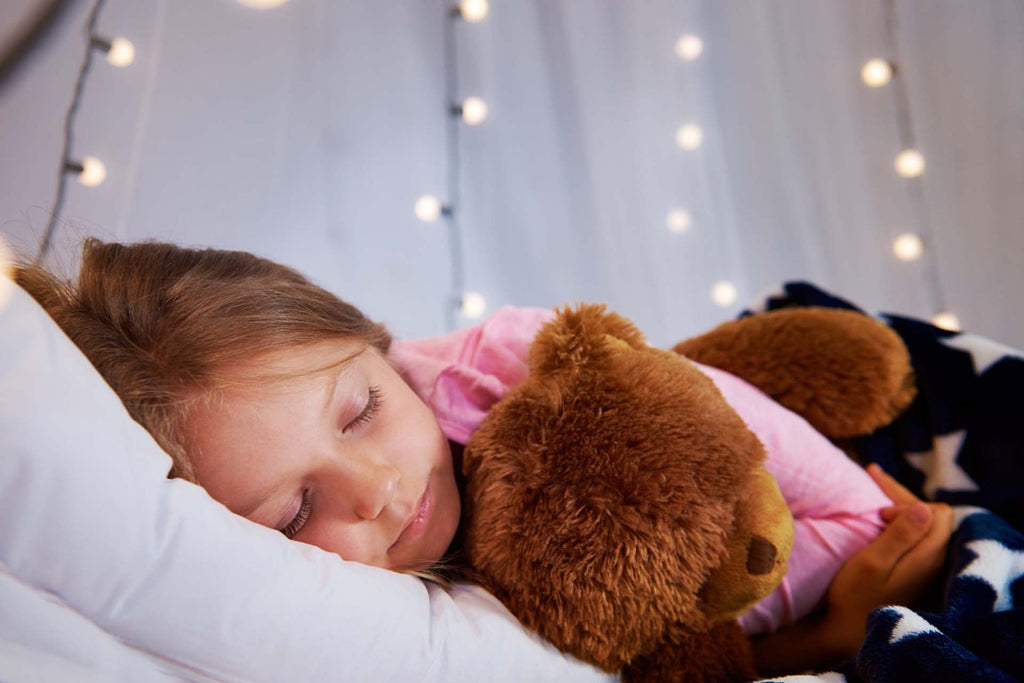 a child sleeping with a stuff toy