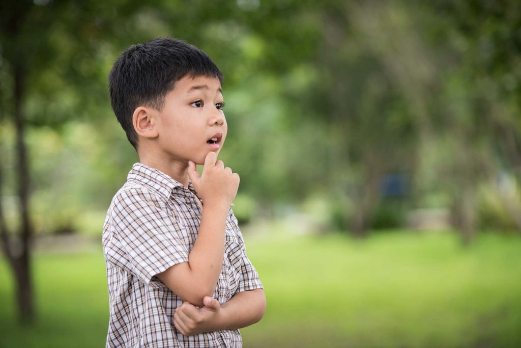 a kid standing outdoor thinking of some ideas