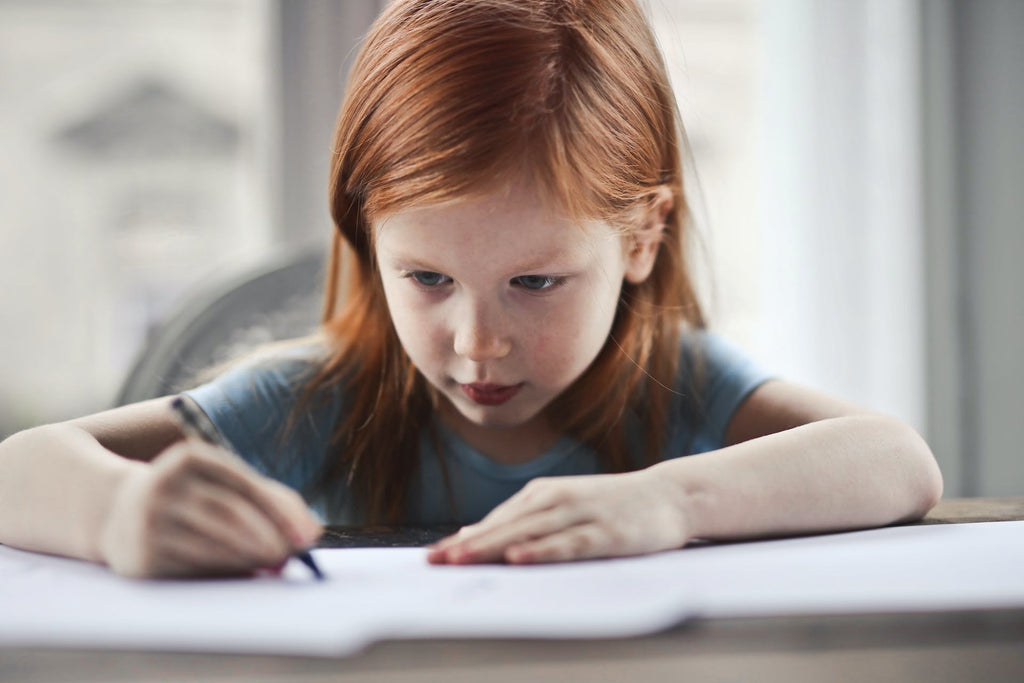 a kid writing on a journal