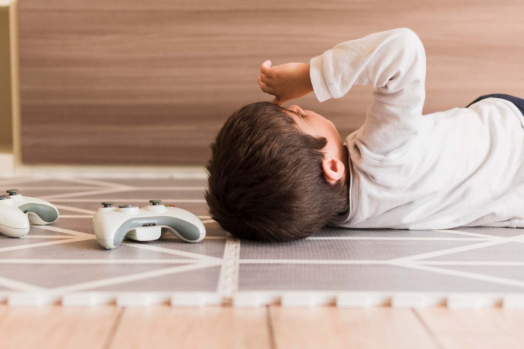 a toddler lying on the floor showing some behavioral issues