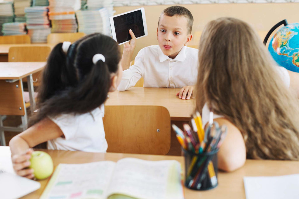 boy distracting girls in class